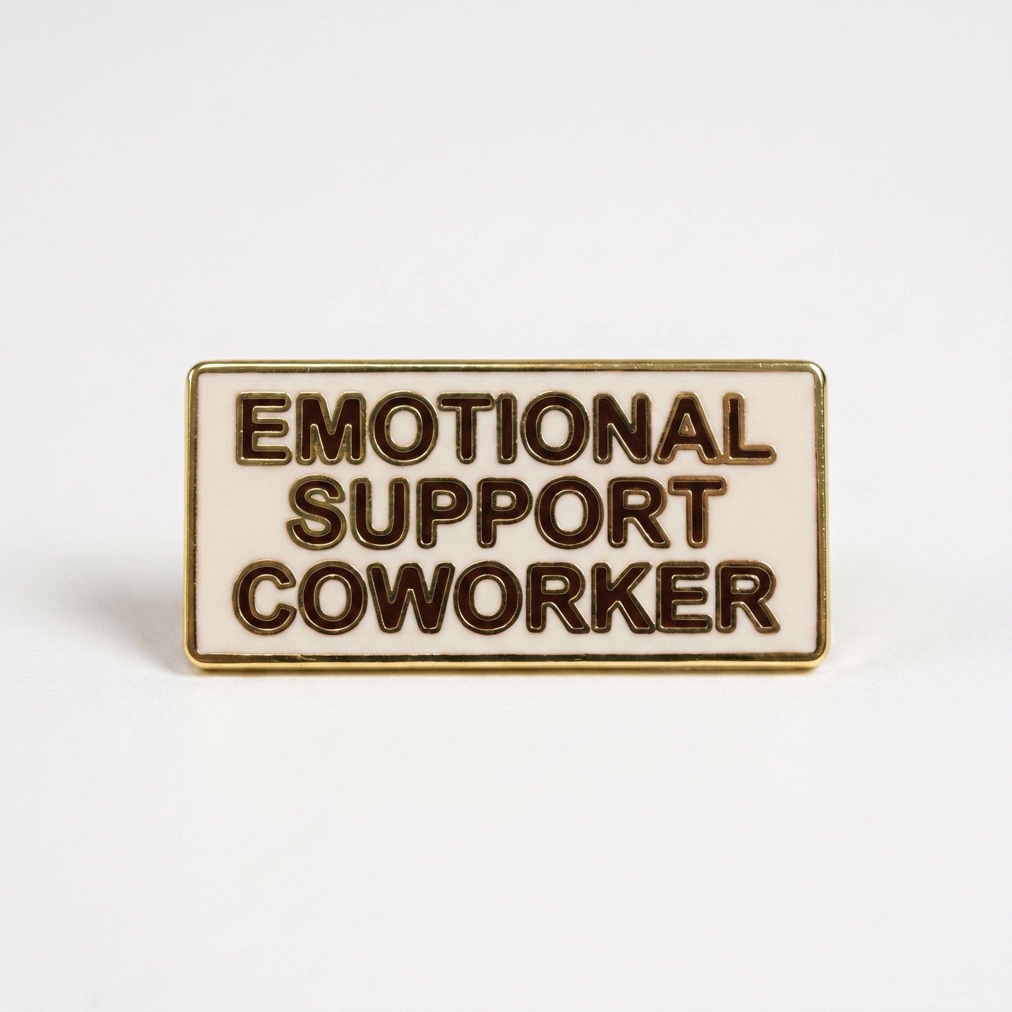 Emotional Support Coworker pin: rectangular cream hard enamel with gold rim and dark brown text.