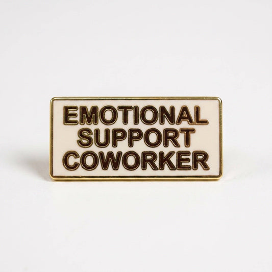 Emotional Support Coworker pin: rectangular cream hard enamel with gold rim and dark brown text.