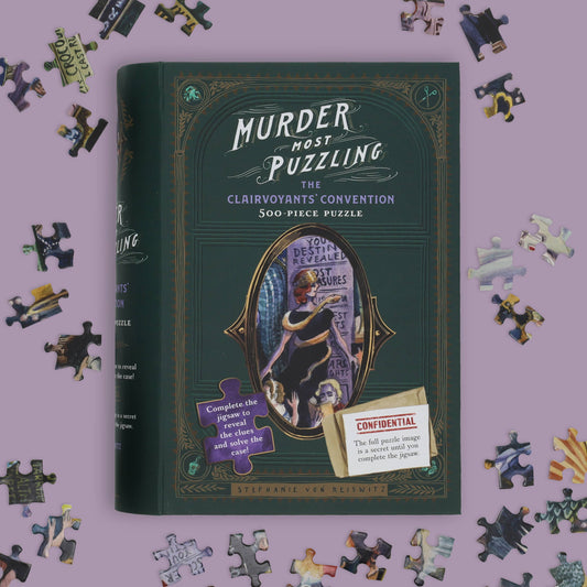 Murder Most Puzzling: The Clairvoyants Convention 500-piece puzzle box with scattered puzzle pieces.