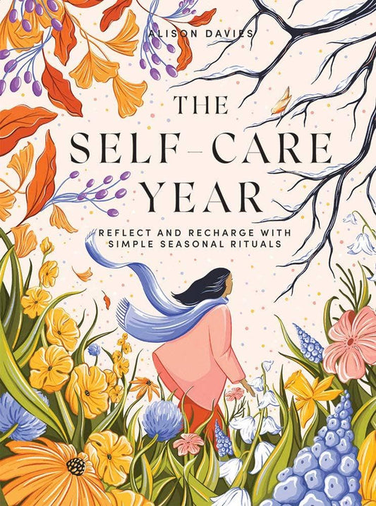 The Self-Care Year book held by a person walking among flowers.