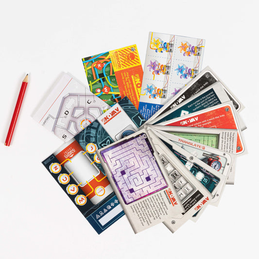 Escape from the Space Station game cards and puzzles with a red pencil on a white surface.