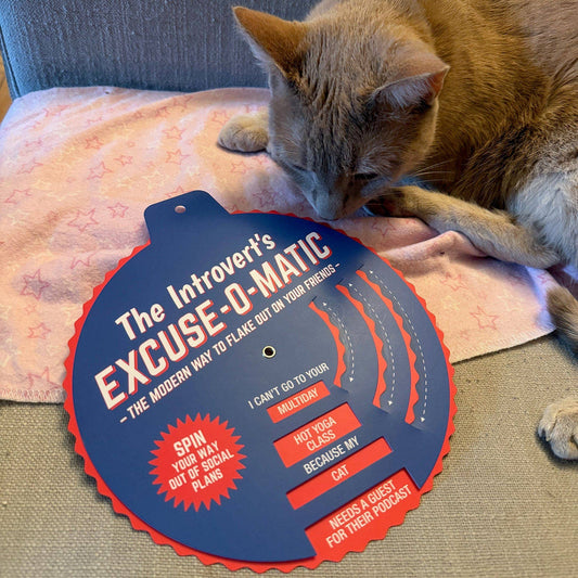 The Introverts Excuse-o-Matic excuse generator shown with a cat sitting beside it.