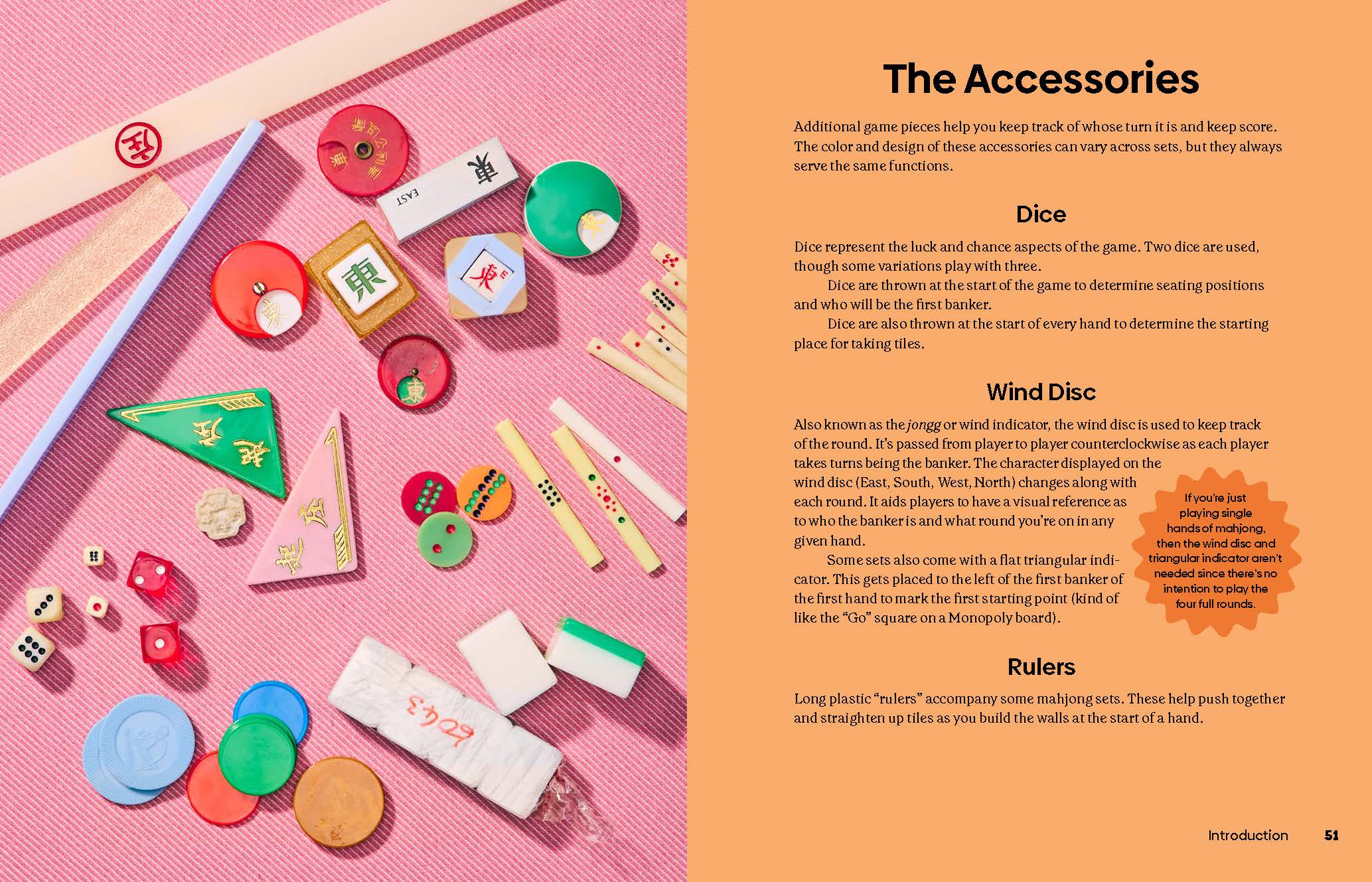 Mahjong set with colorful dice, rulers, game pieces, and a how-to guide on a pink background.
