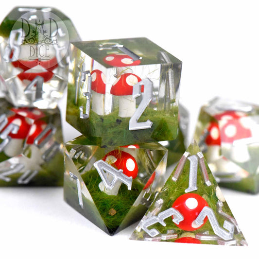Clear resin dice set with silver numbers, red and white mushrooms, and green moss inside.