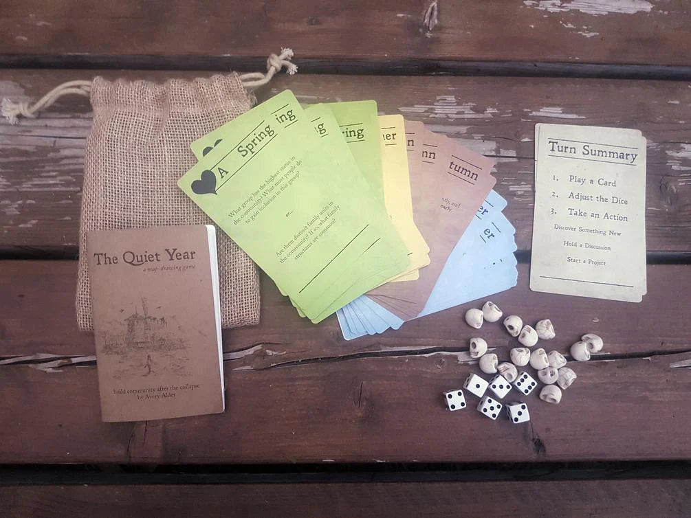 The Quiet Year updated bag set with multicolored cards, dice, tokens, rulesheet, and cloth bag.