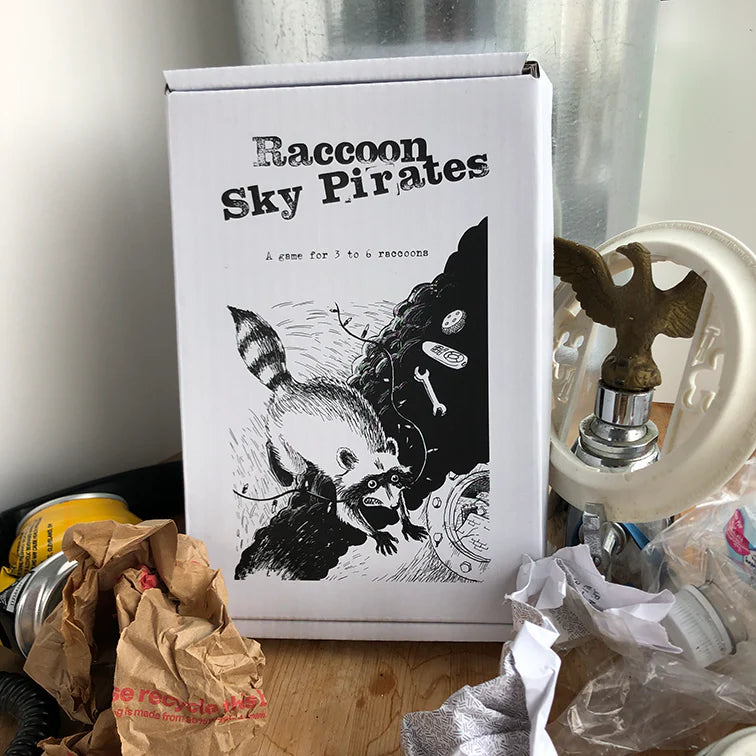 Raccoon Sky Pirates (Revised) game box on a cluttered surface.