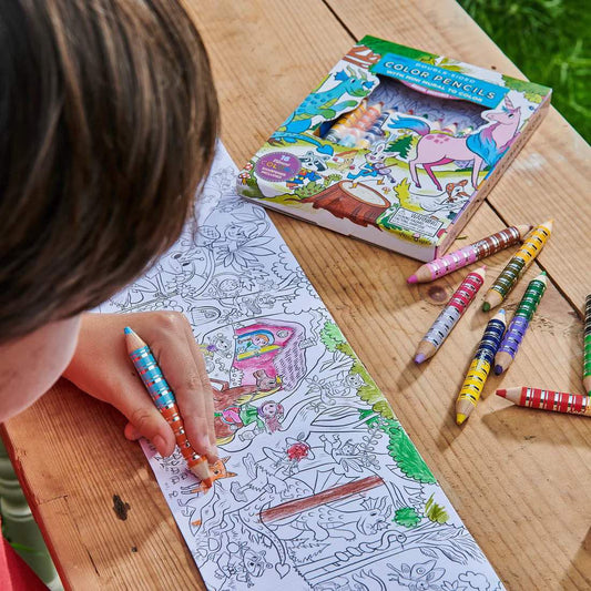 Magical Creature Color Pencil Mini Mural Set with pencils on a wooden table, being colored by a child.