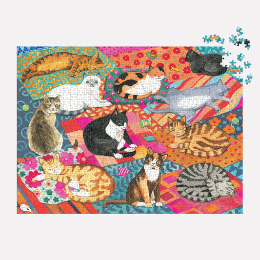 The Lounging Cats 1000 Piece Puzzle with playful cats on rugs and missing pieces in the top right corner.