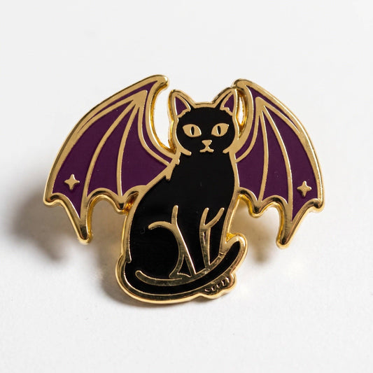 Gold-plated hard enamel pin featuring a black cat with purple bat wings.