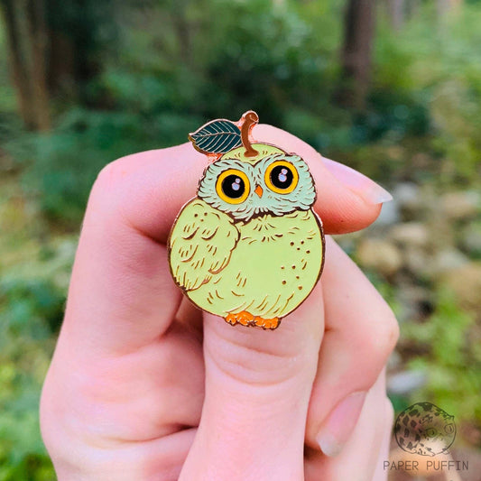 Light green pear-shaped owl enamel pin with a stem and leaf on its head.