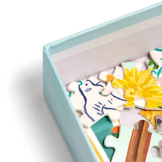 Tea Time 500-piece jigsaw puzzle box with pieces showing a blue animal and yellow flower.