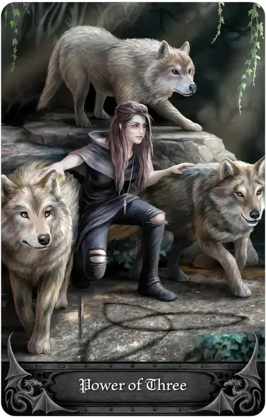 A person kneels with three wolves in a forest. Text reads Power of Three, referencing Anne Stokes Gothic Oracle artwork.