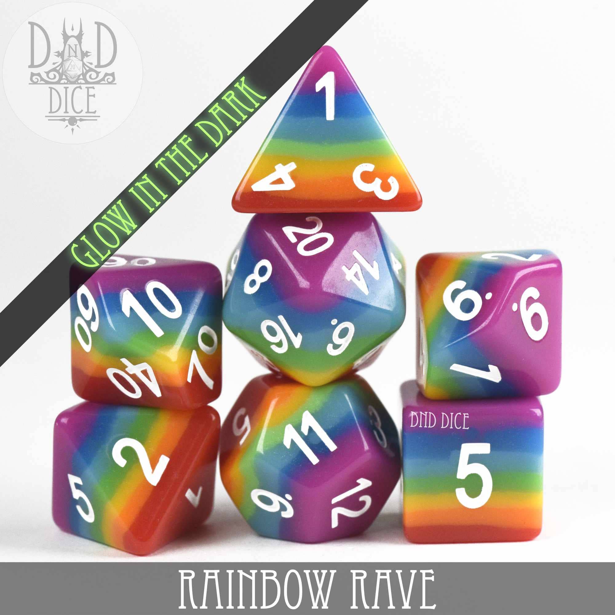 Rainbow Rave (Glow) 7-dice set: rainbow-striped resin dice with white numbers that glow in the dark.