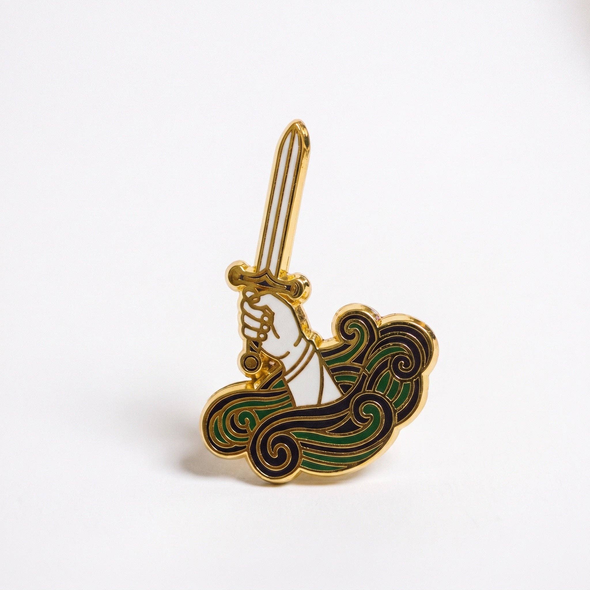 Lady Of The Lake gold-plated hard enamel pin: a hand rising from stylized waves holding a white sword.