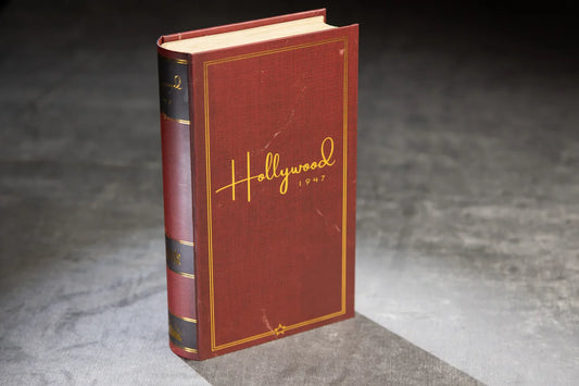Hollywood 1947 vintage red book inspired by a social deduction game, displayed upright on a gray surface.