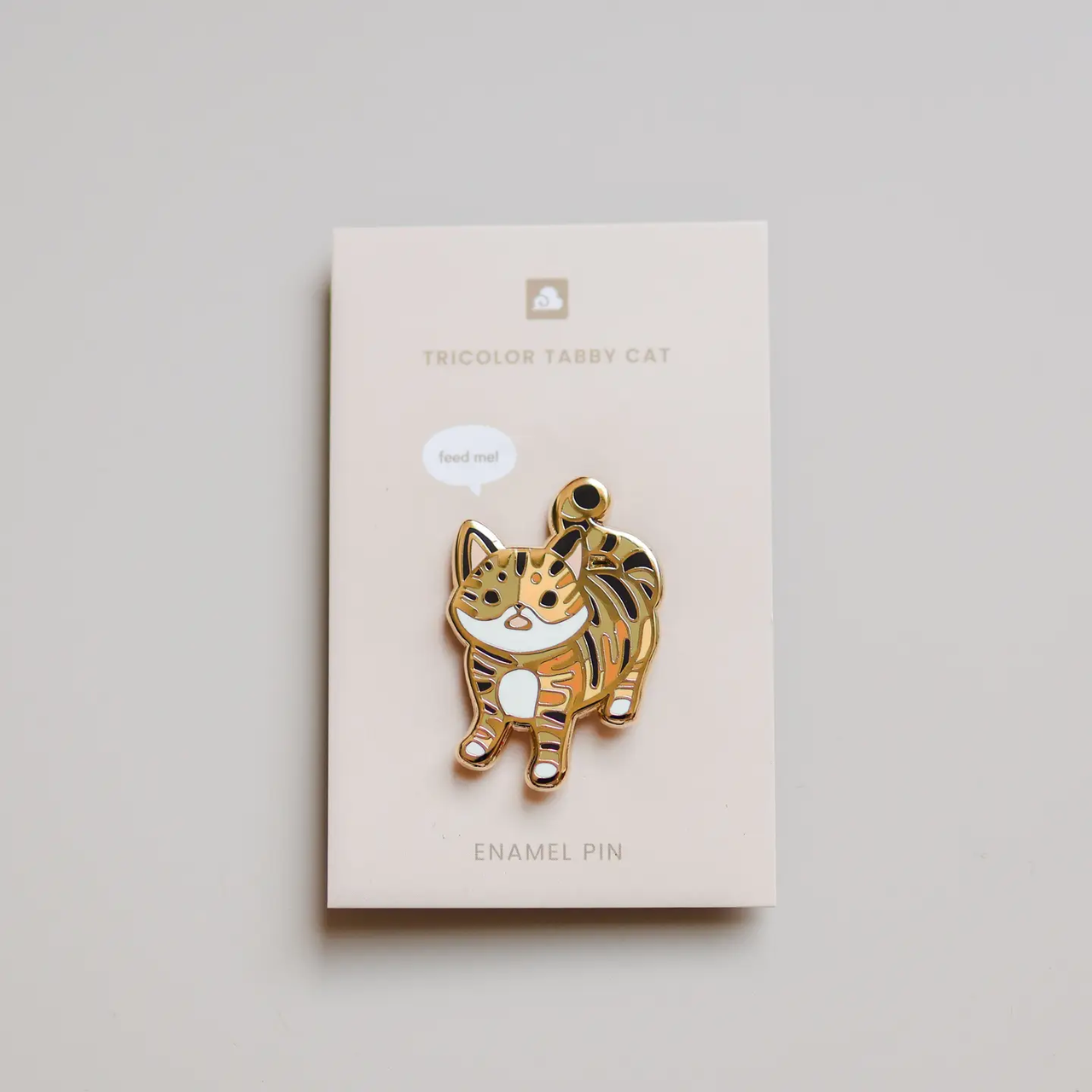 Tricolor Tabby Cat enamel pin on a backing card labeled Tricolor Tabby Cat against a plain background.