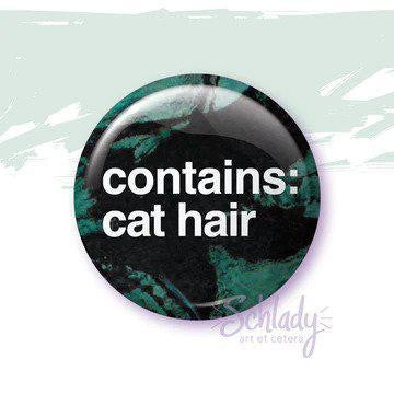 A 1.25 round pinback button with the text Contains Cat Hair.