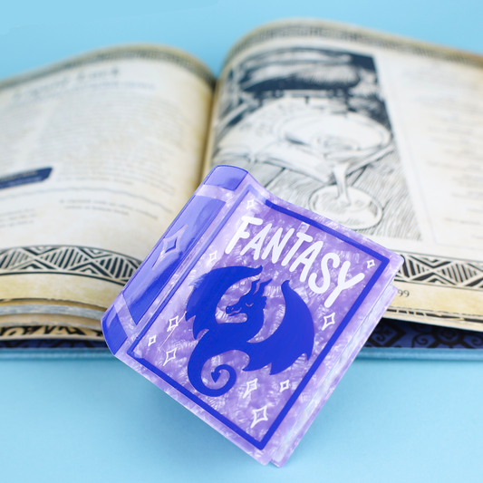 Purple Fantasy Book hair claw on a blue surface.