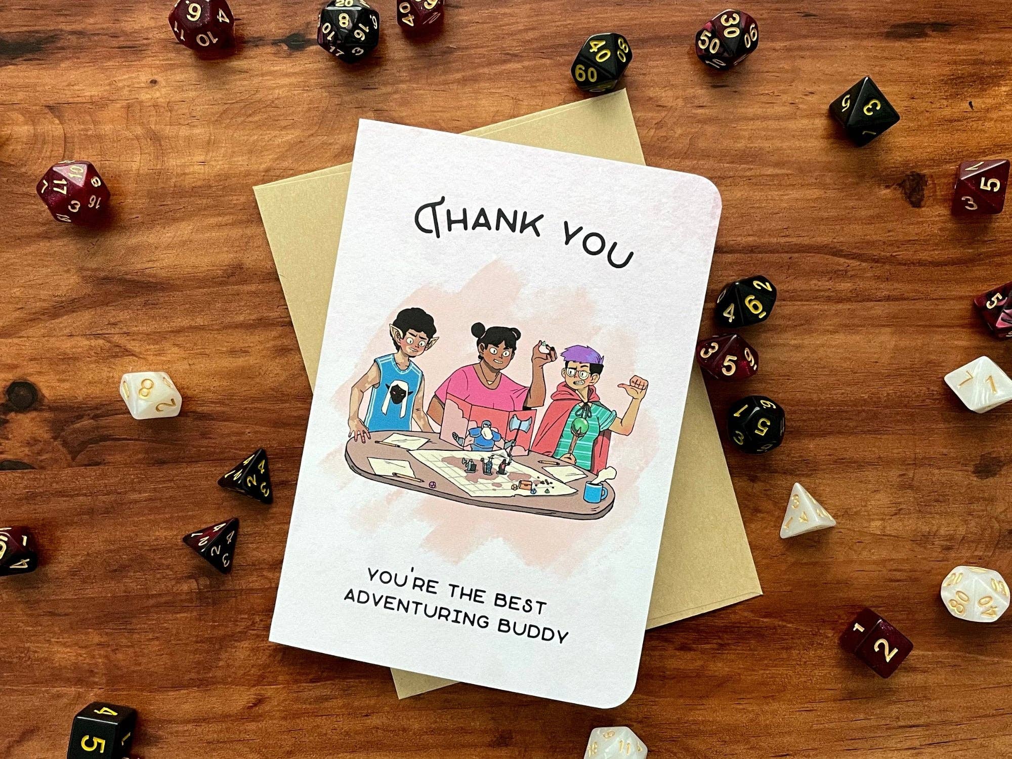 Thank You Adventuring Buddy Greeting Card featuring three friends playing tabletop RPG with dice on a wooden table.