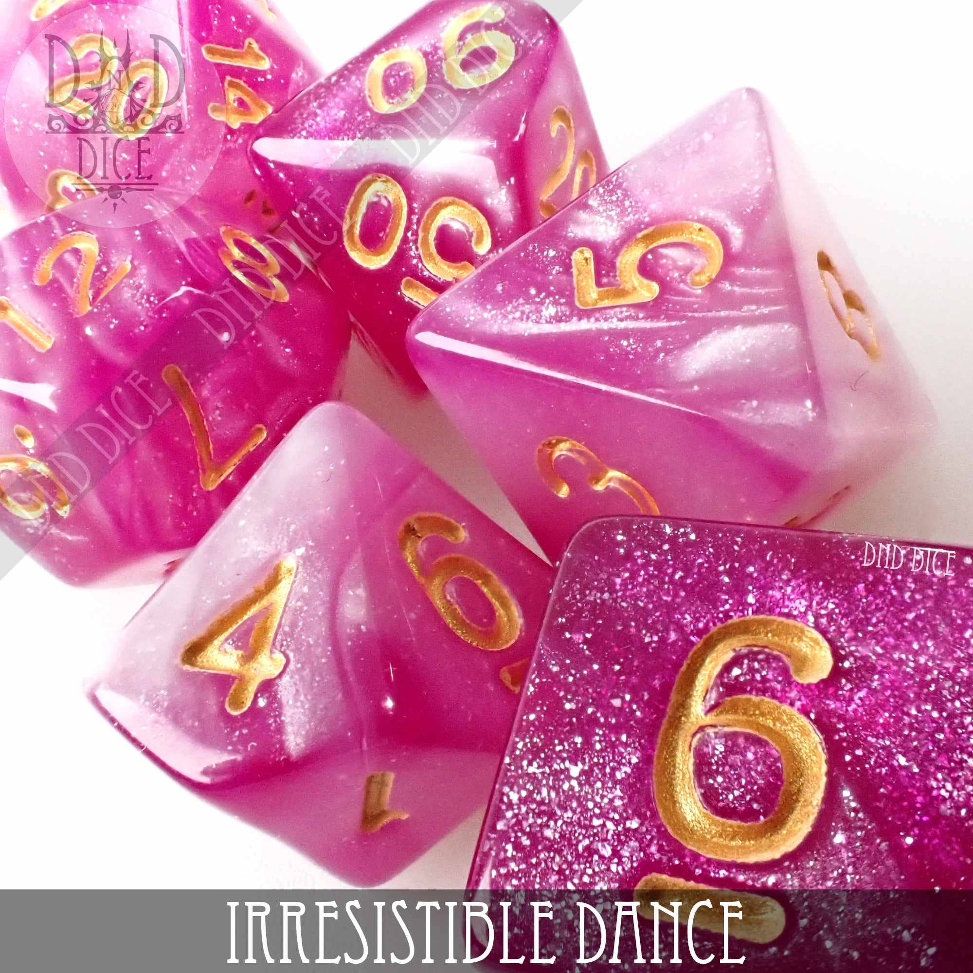 Pink and white acrylic Irresistible Dance DnD dice set with gold numbers on a white surface.