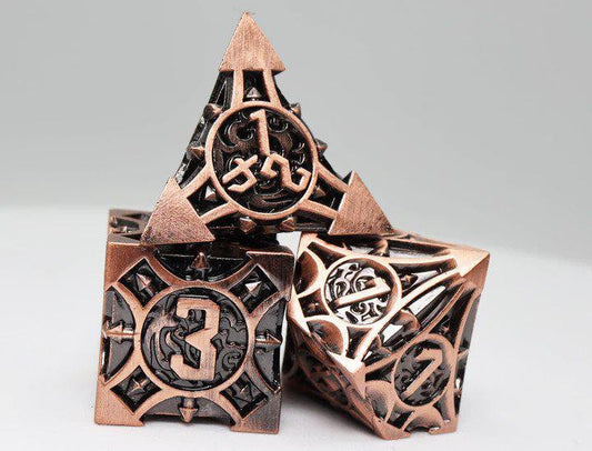 Three intricately carved Copper Arrow RPG metal dice by Foam Brain Games, showing numbers 1, 3, and 7.