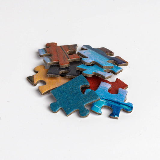 Six colorful Puzzle - René Magritte - Personal Values pieces stacked on a plain white background.