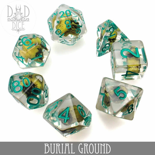 Burial Ground 7-dice DND set in clear resin with teal numbers and small yellow flowers. Dice are arranged in a circle.