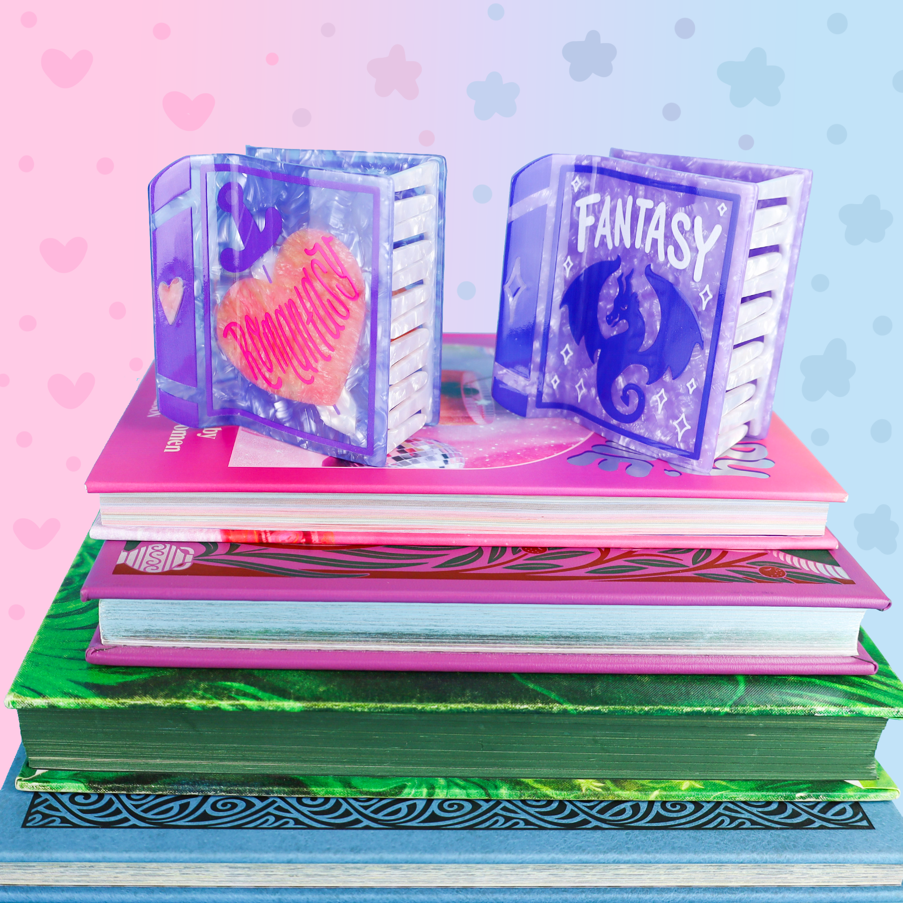 Mini purple Fantasy book and Fantasy Book hair claw accessory next to a stack of four colorful books.