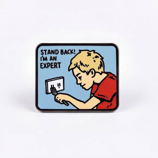 Expert Pin: hard enamel pin depicting a person sticking a fork into an electrical outlet with text STAND BACK IM AN EXPERT.