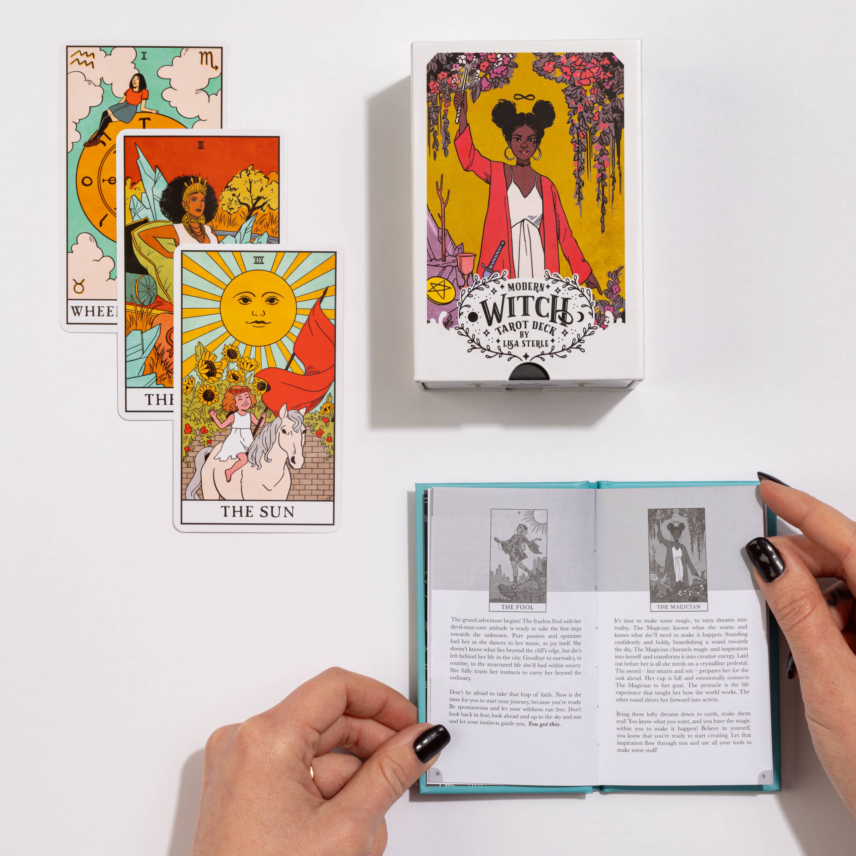 Modern Witch Tarot Deck guidebook, three tarot cards, and box displayed on a white surface.