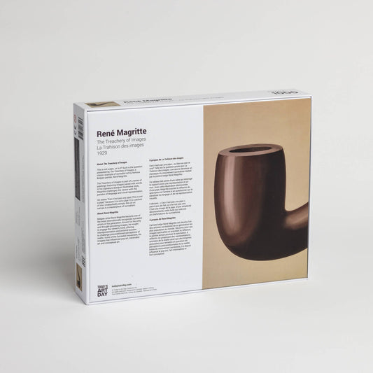 Back of René Magritte puzzle box featuring The Treachery of Images art and multilingual product text.