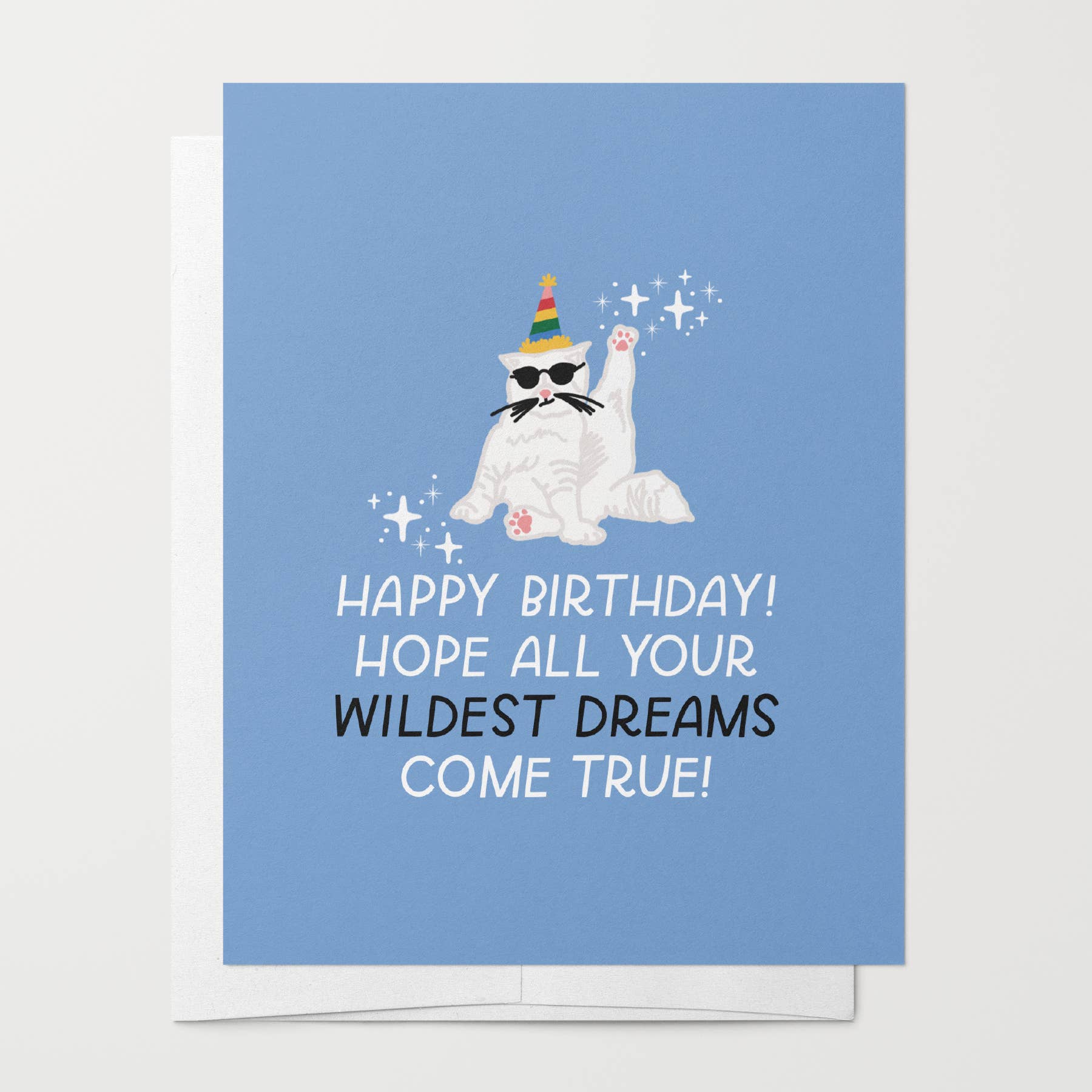 Wildest Dreams birthday card with a white cat wearing sunglasses and a party hat on a blue background.