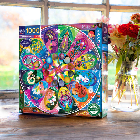 Horoscope 1000 Piece Puzzle with zodiac signs on a table near a window and a vase of flowers.