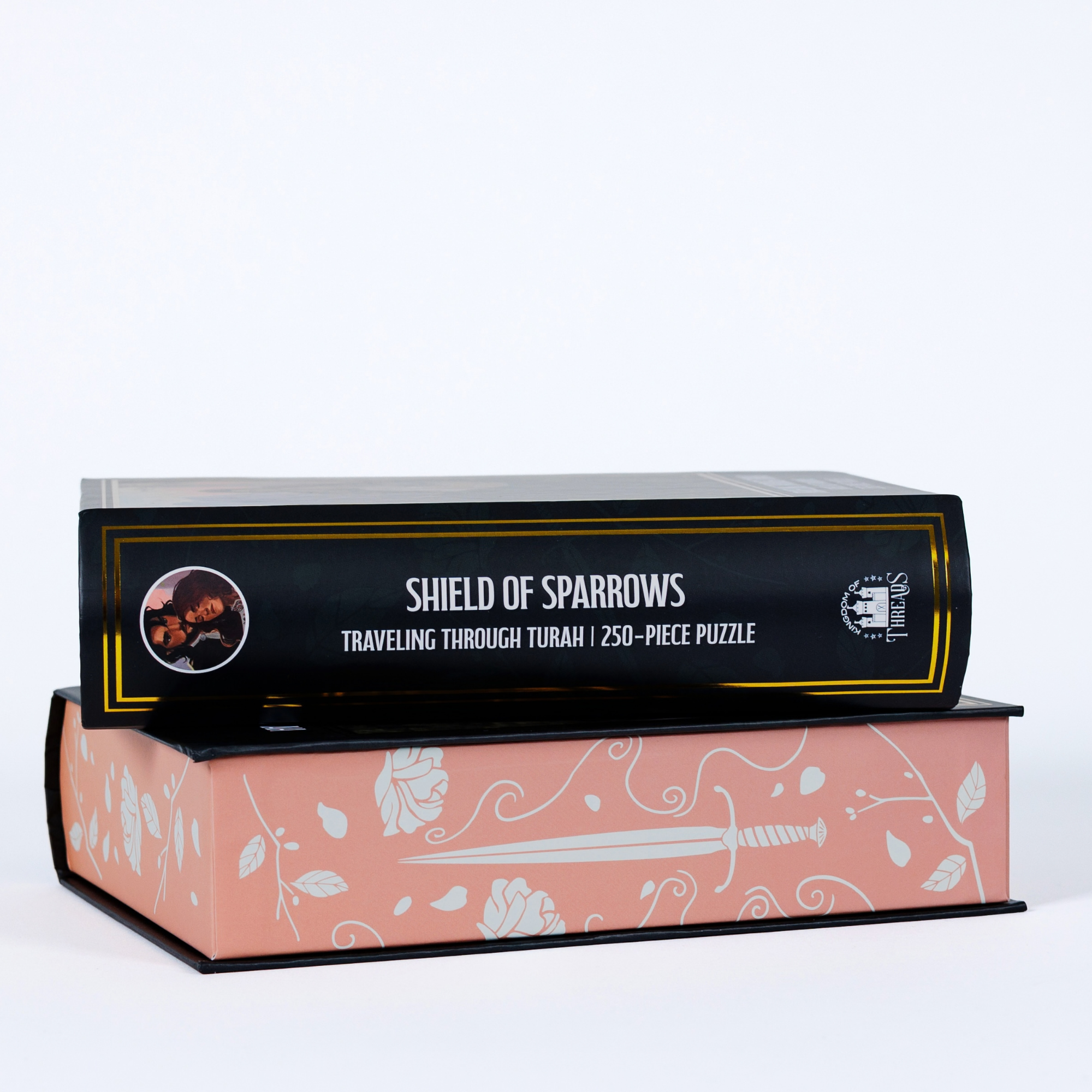 Traveling Through Turah Shield of Sparrows 250-piece puzzle, sword & rose design, packed in a book-shaped box.