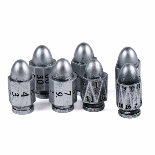 7-piece metallic polyhedral dice set shaped like bullets, each engraved for tabletop gaming.