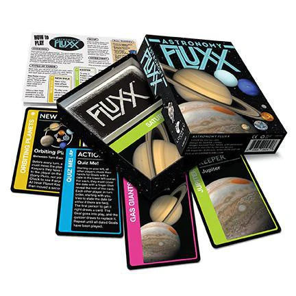 Astronomy Fluxx card game with planet-themed cards, game box, and instructions on a white surface.