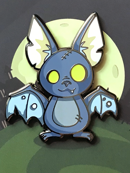 Zombat Bat Enamel Pin (Glow-in-the-Dark) with cartoon bat, glowing eyes, blue wings, and a full moon background.