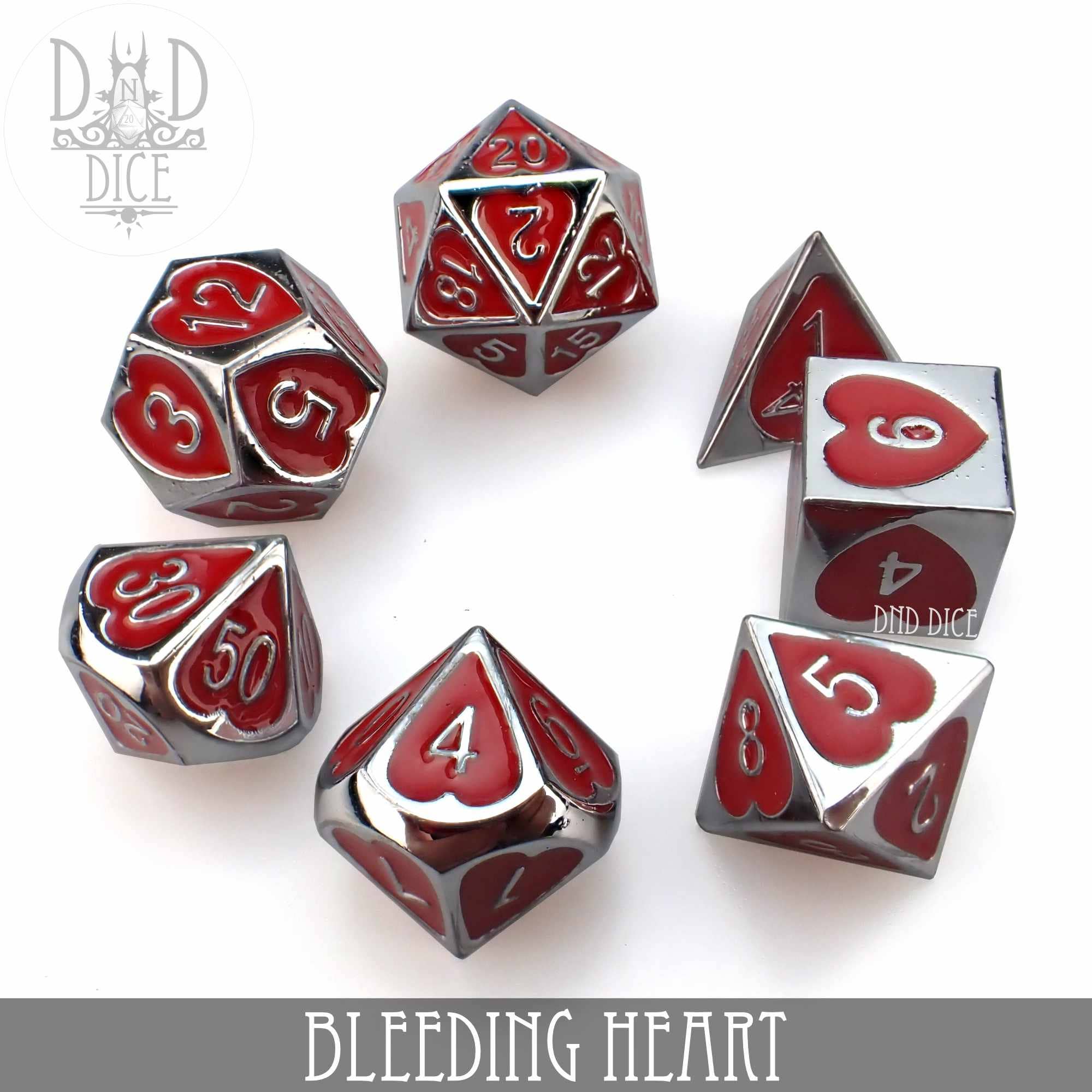 Seven silver-colored zinc alloy Bleeding Heart RPG dice with red heart detailing on every face.