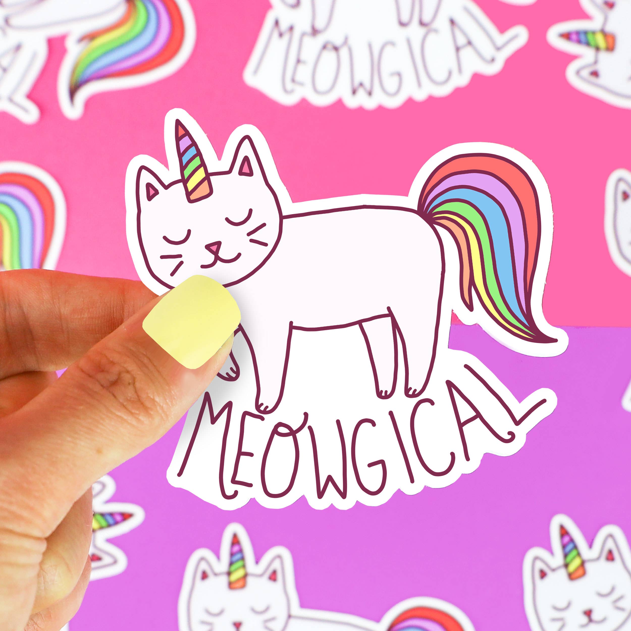 Meowgical Magical Cat Rainbow Vinyl Sticker showing a cat with a unicorn horn and rainbow tail held in a hand.
