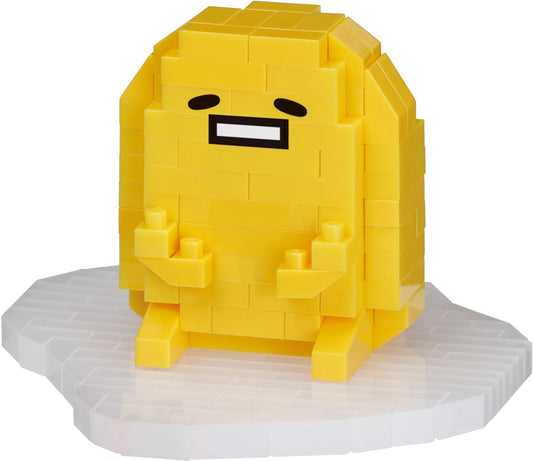 Sanrio Nanoblock Gudetama Dress Up, yellow brick figure, seated on white Nanoblock platform.