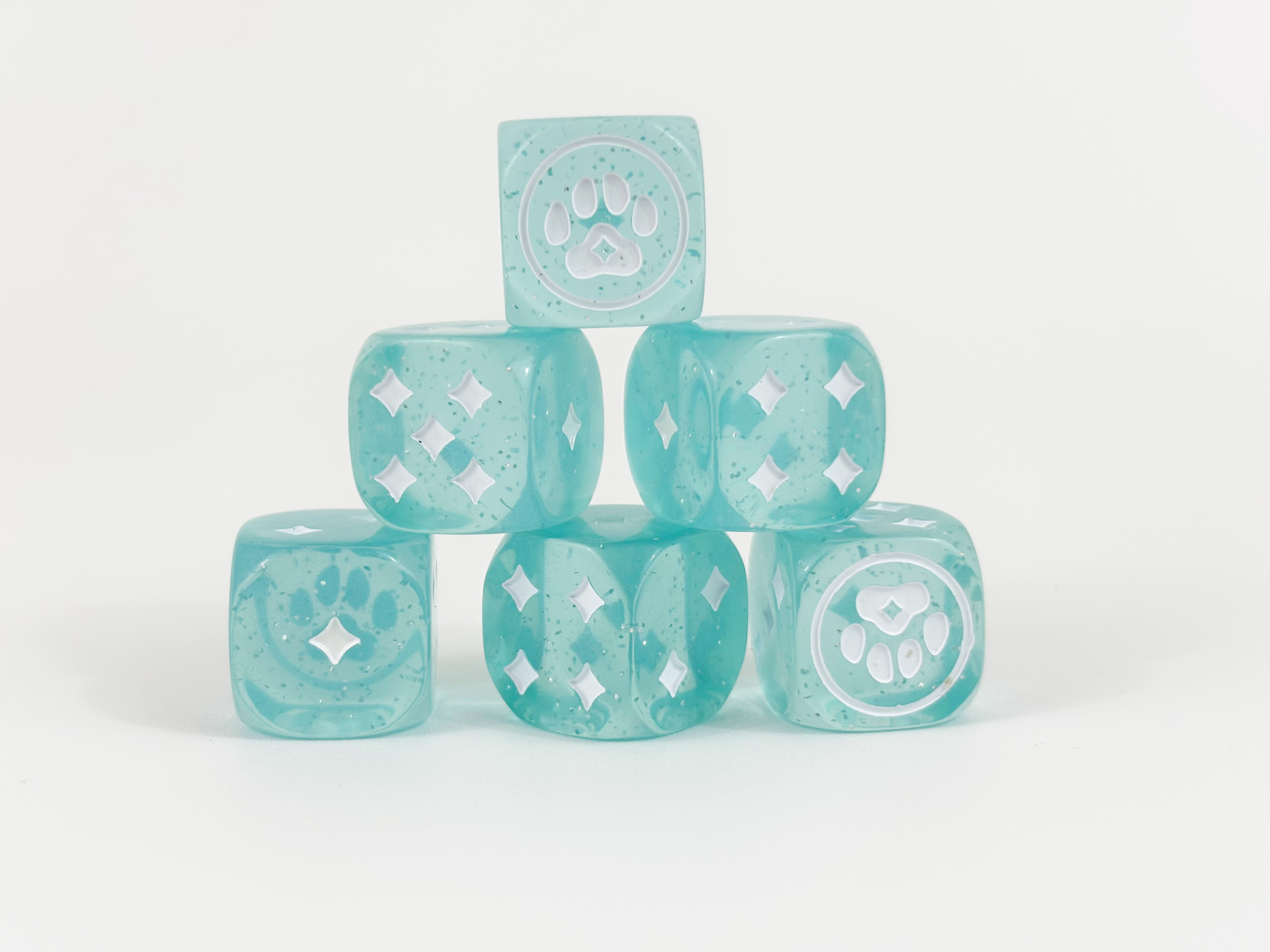 Six teal 20mm dice from the Magical Kitties Save the Day Kitty Paw Dice Set stacked in a pyramid.