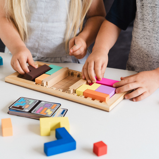 Katamino Family board game with two children assembling colorful wooden block puzzles.