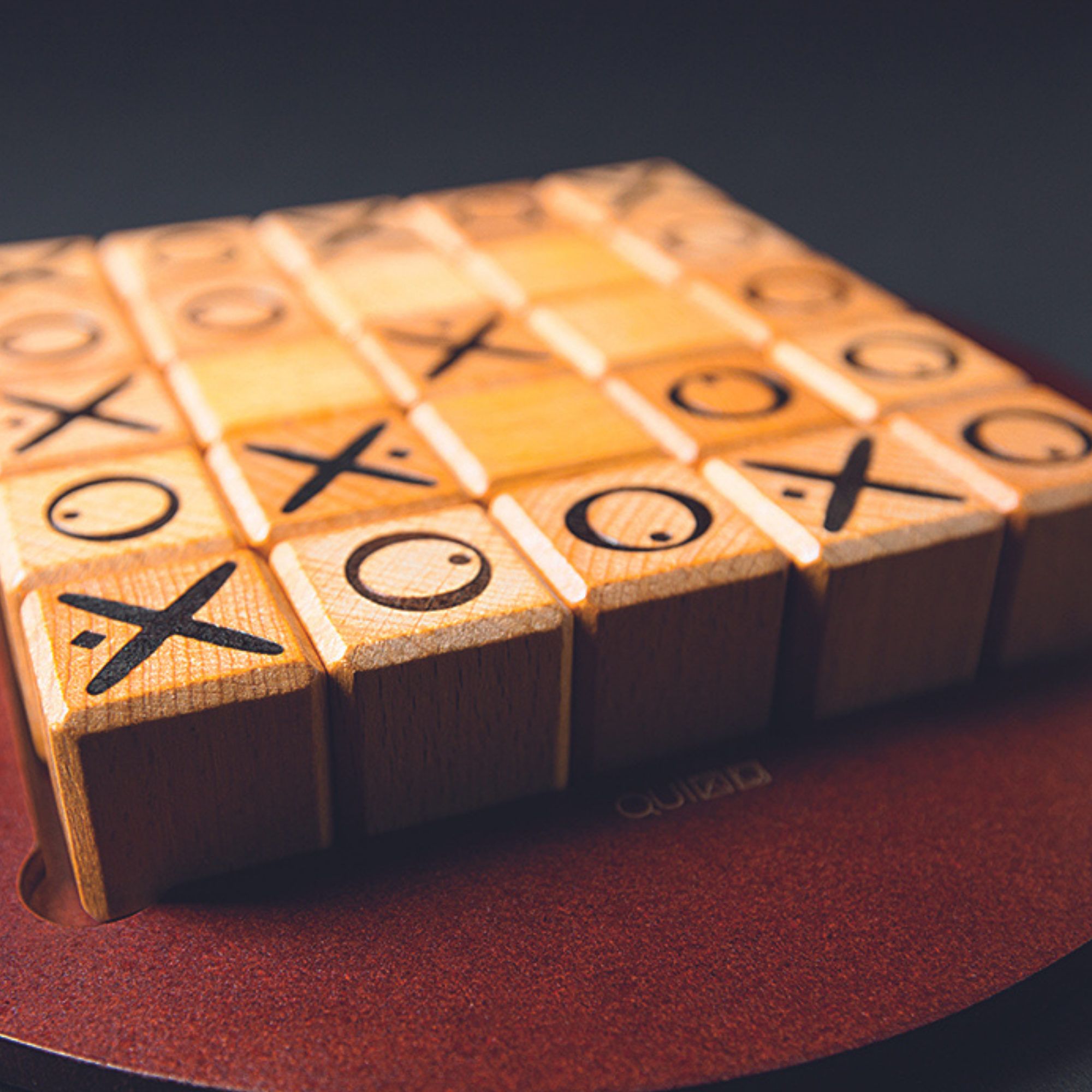 Quixo wooden tic-tac-toe board game with rotating cubes showing X and O symbols.