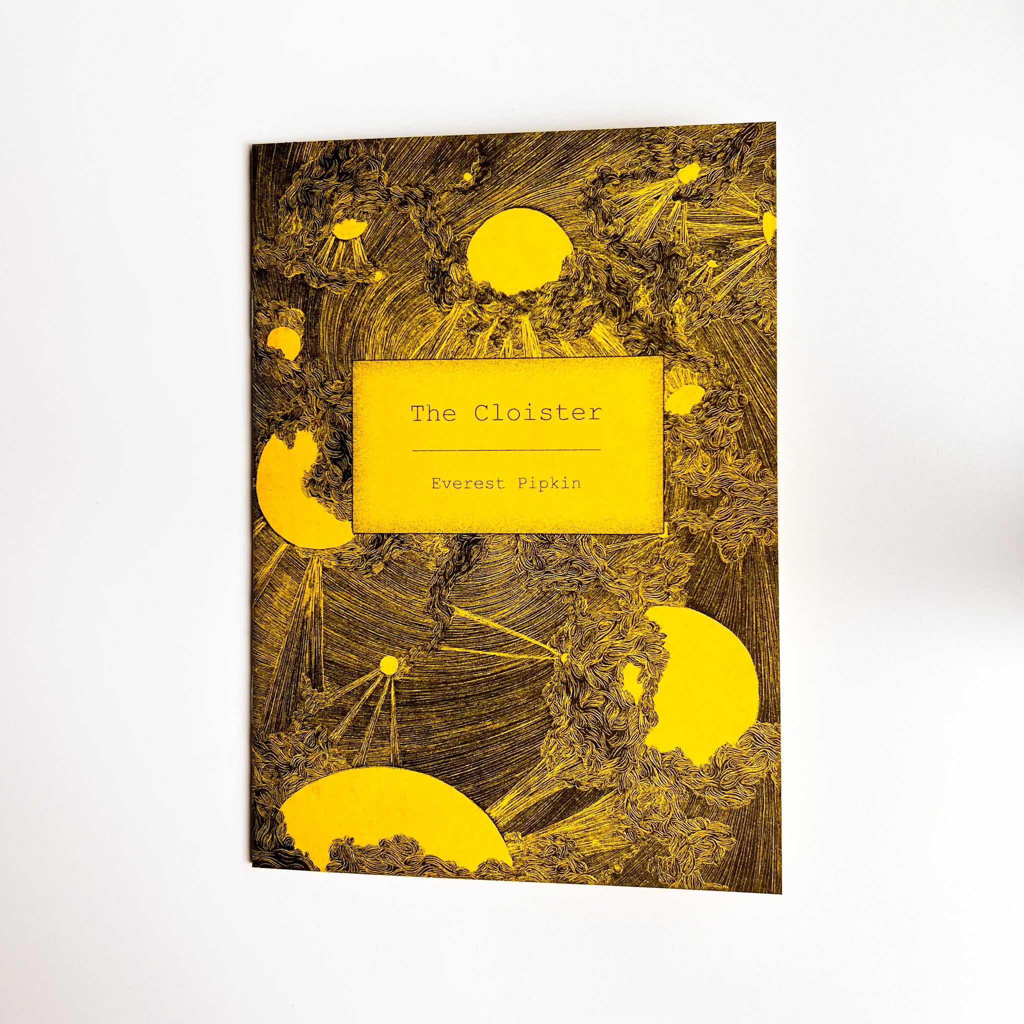 The Cloister two-player storytelling game book with a yellow and black cover featuring an abstract sun design.