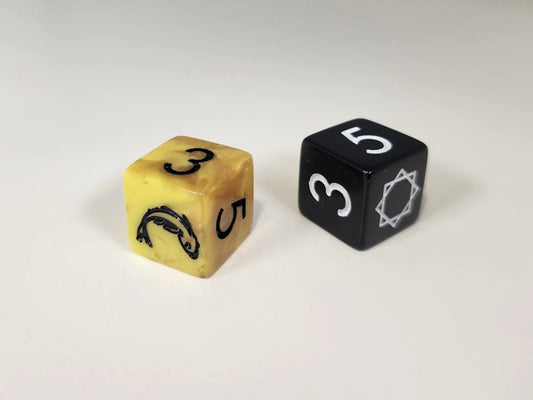 Gold and black six-sided dice, each showing 3 and 5, for The Real Thing RPG.