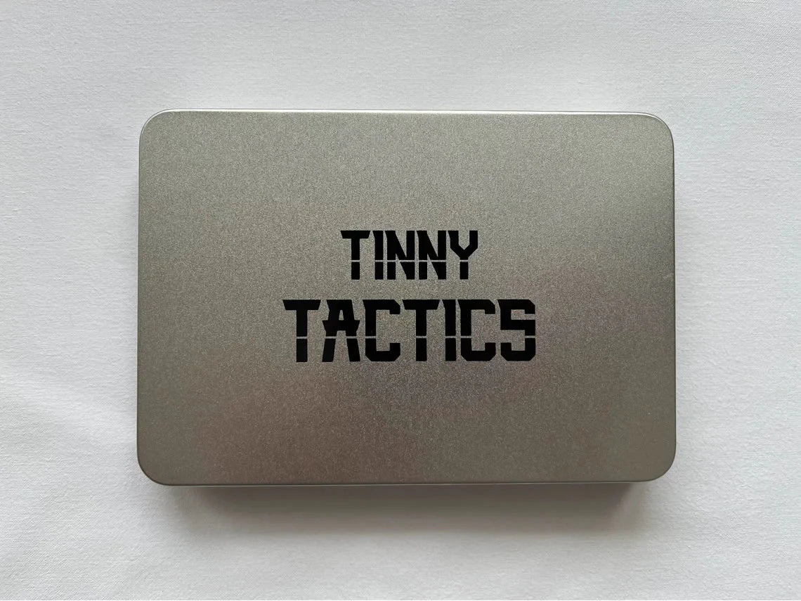 Silver tin labeled Tinny Tactics for storing tabletop wargame pieces.